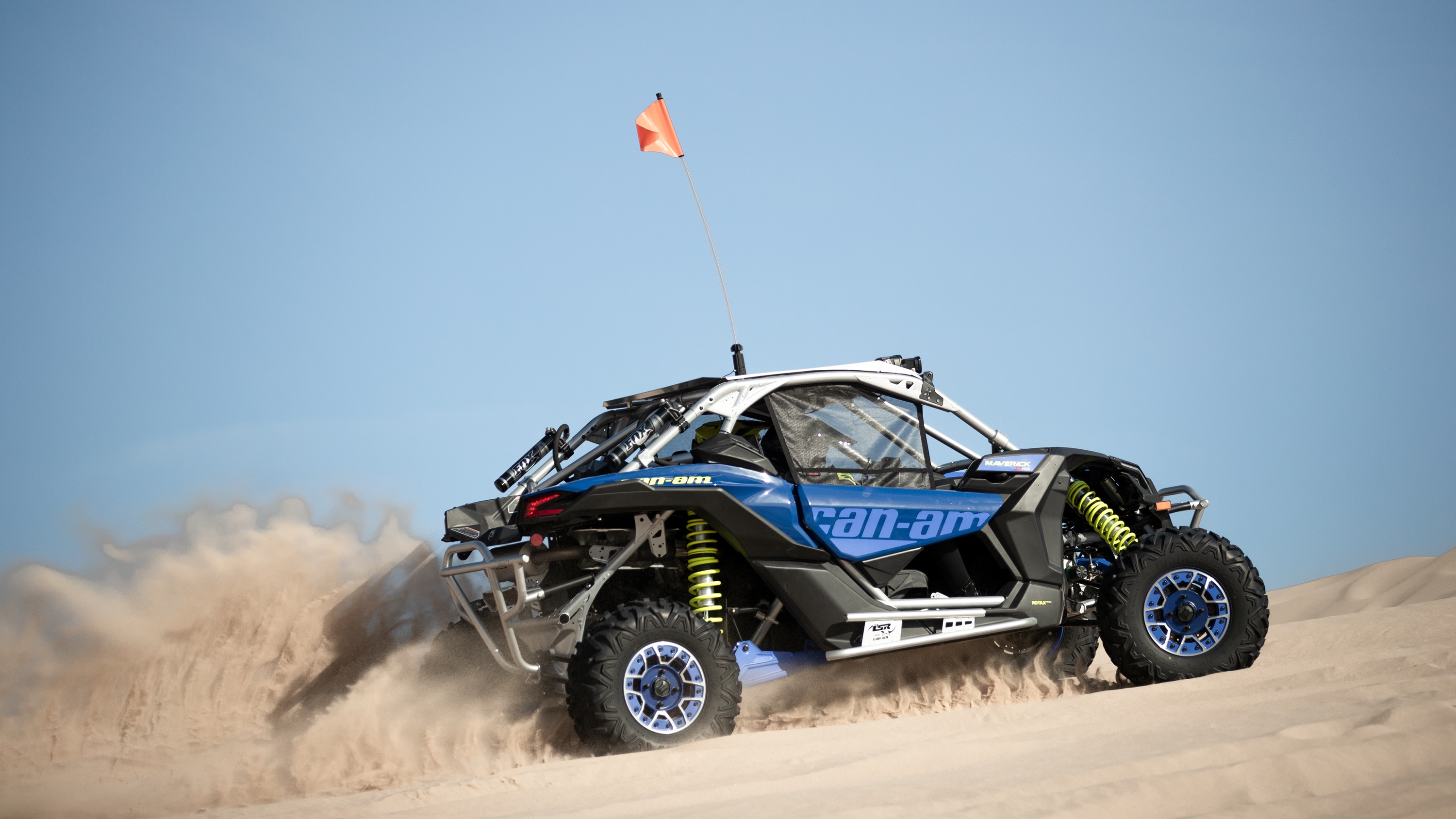 A single Maverick driving up a dune