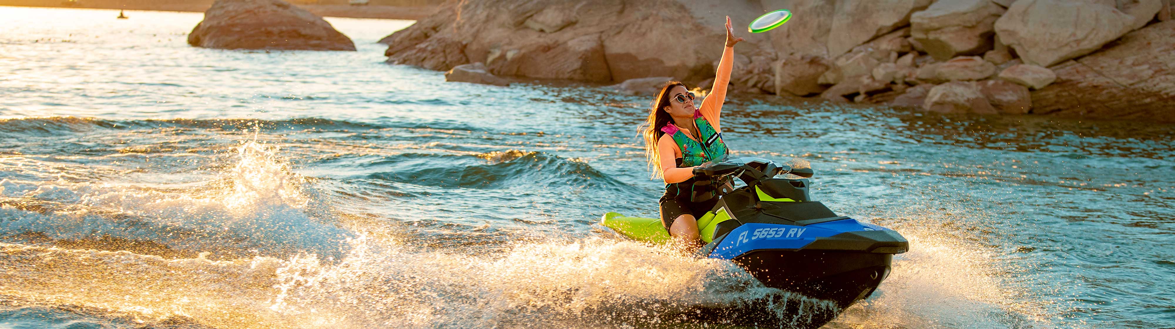 Women driving a Sea-Doo SPARK while catching a Frisbee