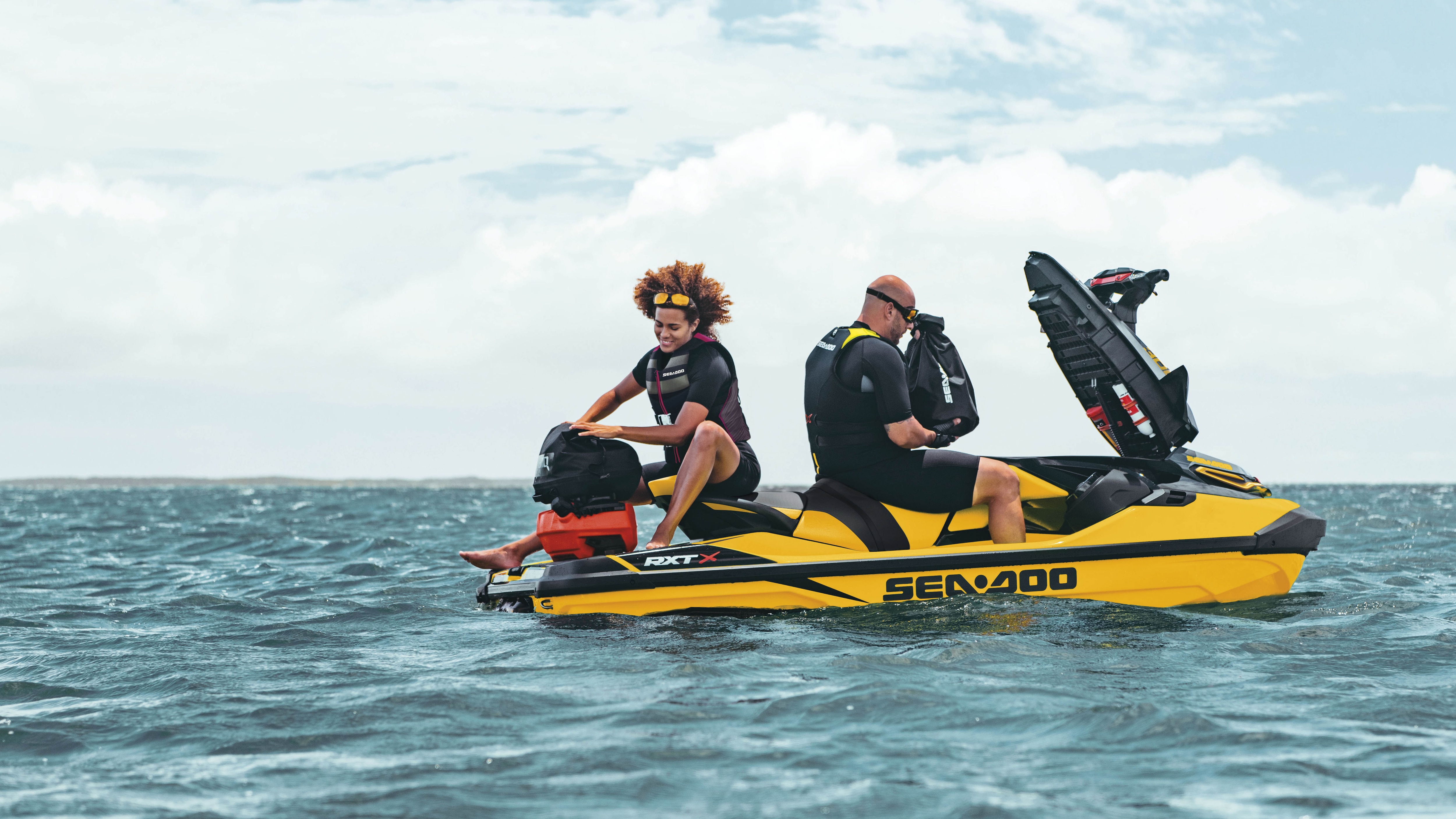 Couple storing bags in a Sea-Doo RXT-X