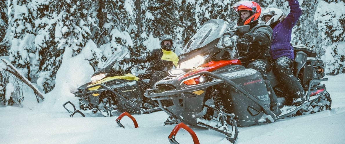 Friends driving a pair of Ski-Doo Expeditions through snow