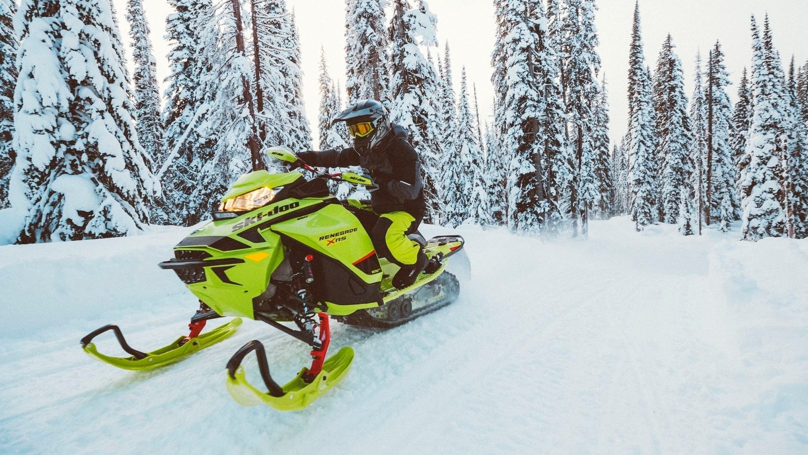 Čovek vozi kroz sneg sa svojim motornim sankama Ski-Doo Renegade