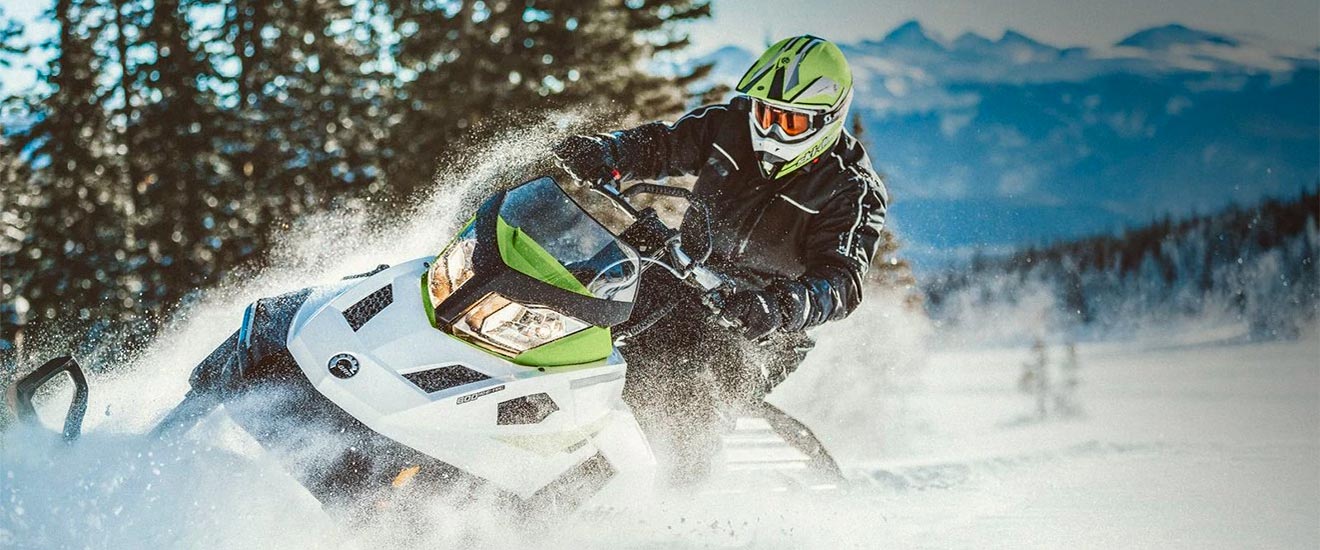 Muškarac vozi svoje Tundra motorne saonice na zasnježenom terenu