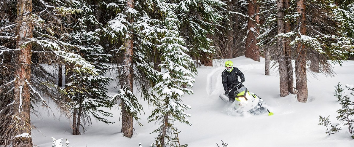 Man going down a small snowy trail with his Ski-Doo Tundra