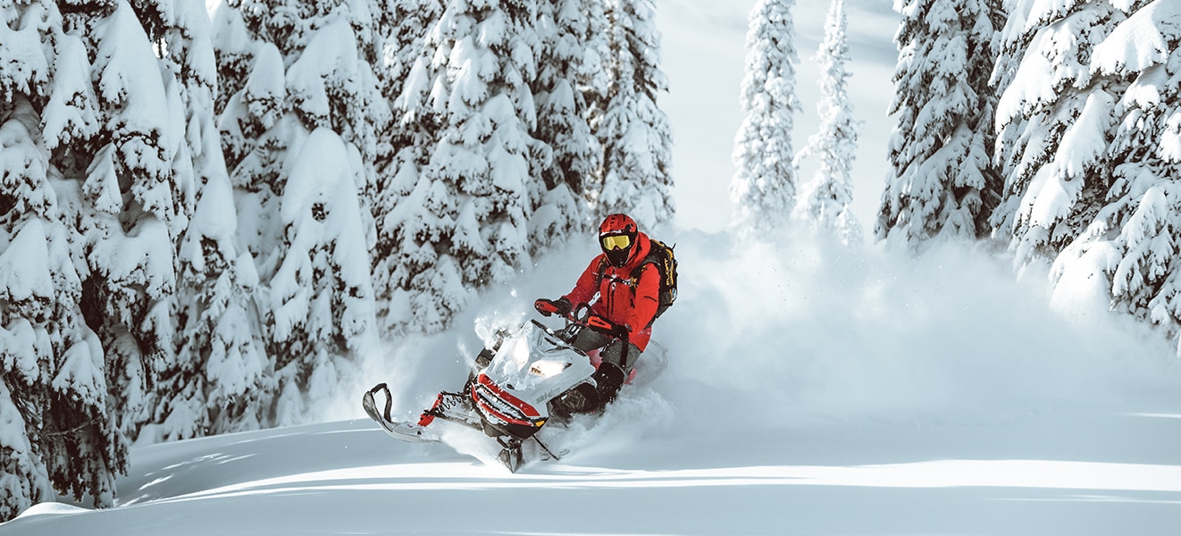 Moški skače po zraku z njegovimi Ski-Doo motornimi sanmi