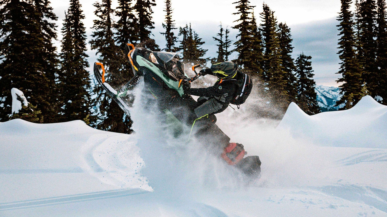Muž skáče počas jazdy na Ski-Doo Expedition Xtreme