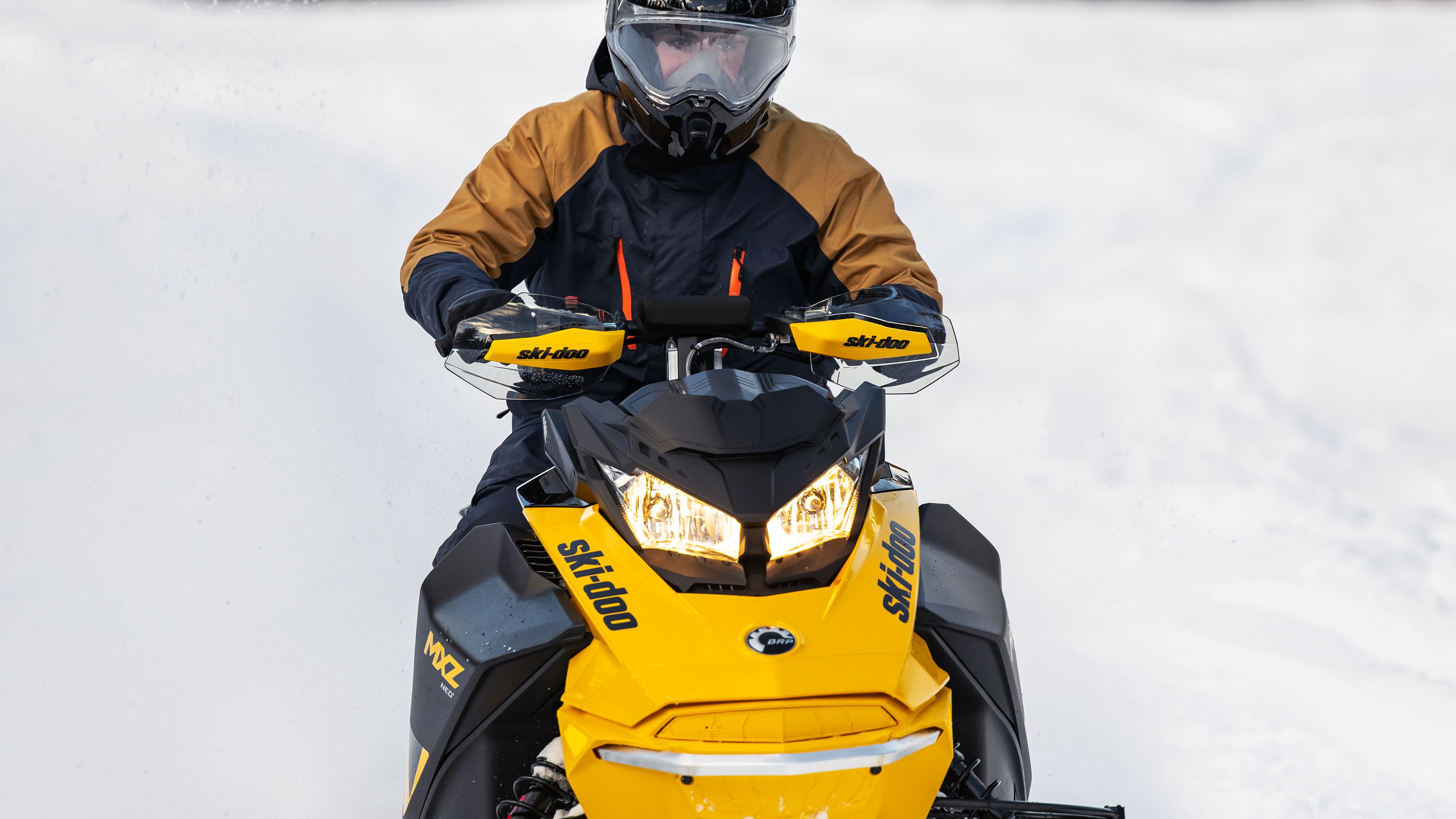 Muž má na sebe bundu MCode 3-in-1 Jacket počas jazdy na Ski-Doo 