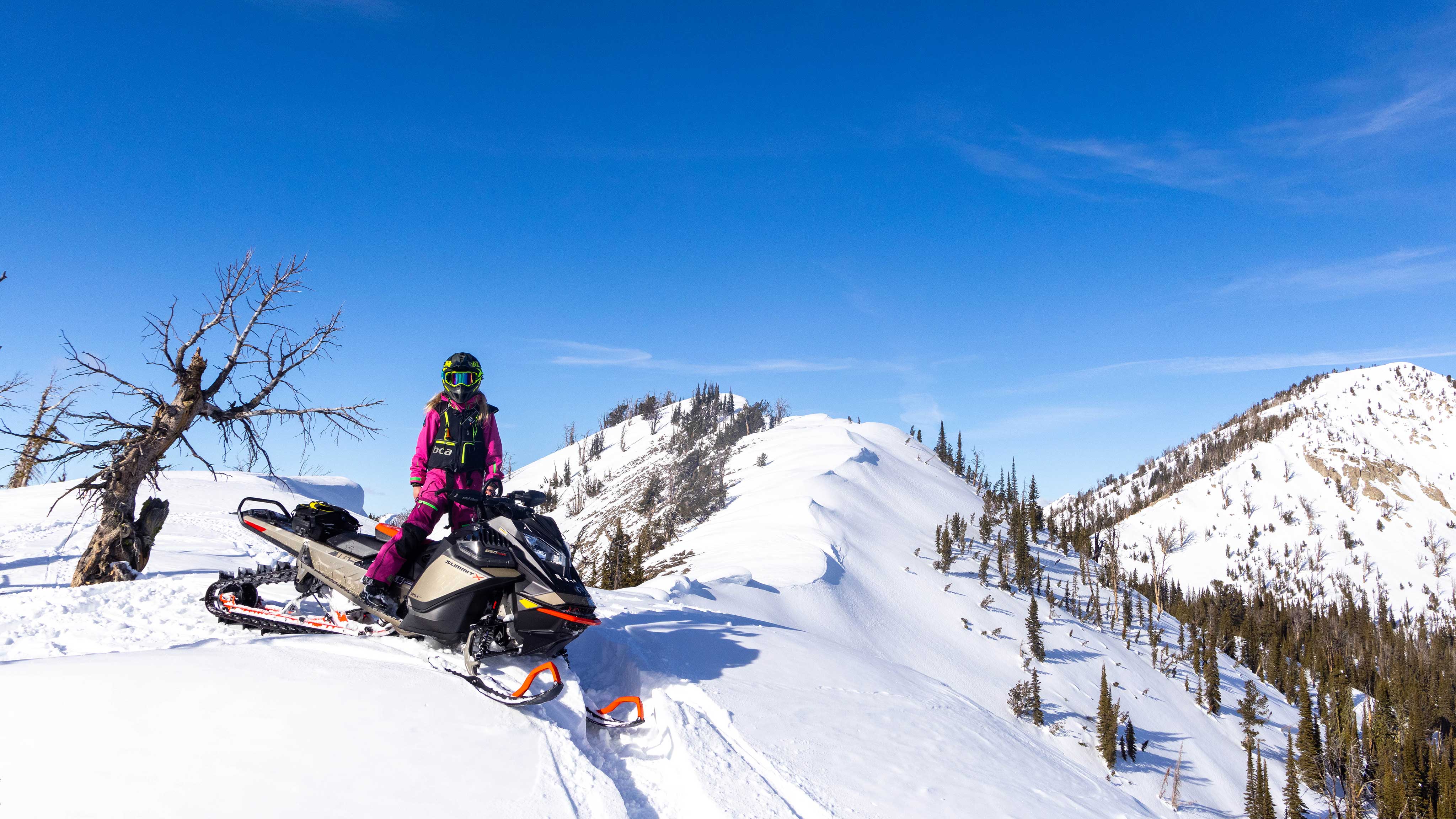 Lisa Granden na vrchole hory na jej skútri Ski-Doo 
