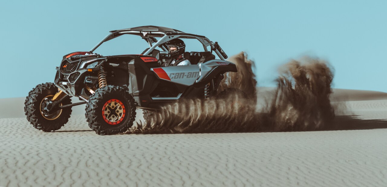 Man driving a Can-Am Maverick in the sand