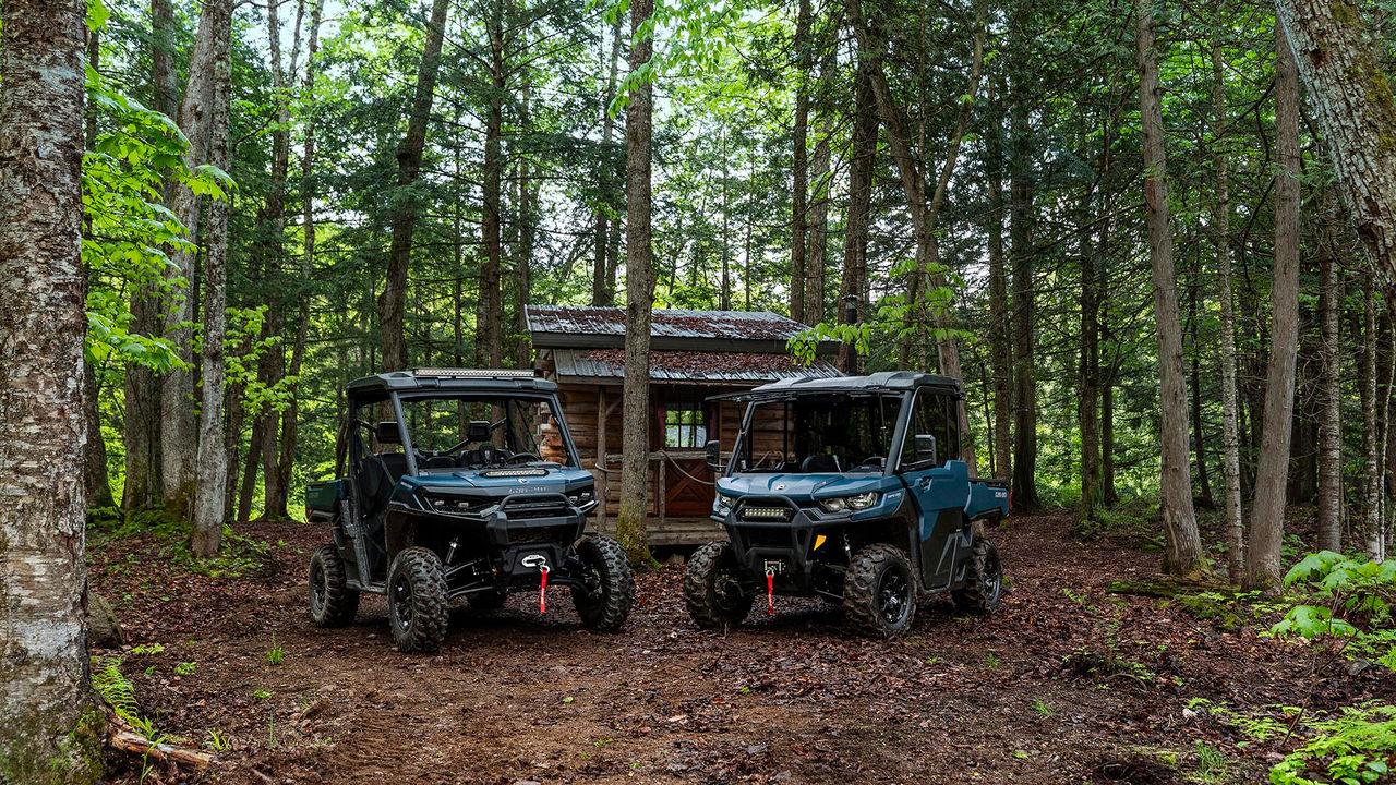 The two 2026 Can-Am Traxter models parked side by side in the forest