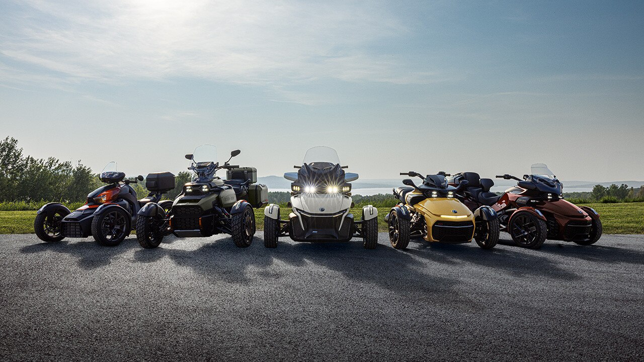 Several new 2026 Can-Am 3-wheel models placed next to each other in front of a field