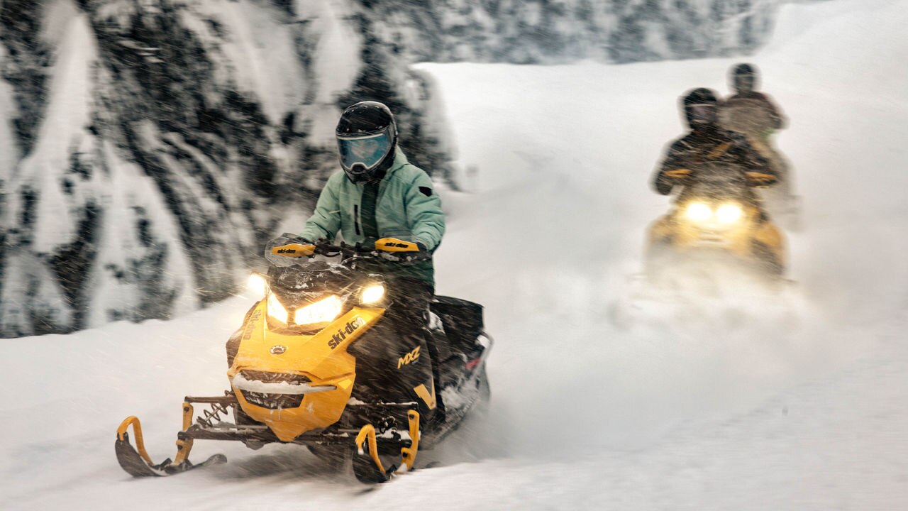 Dvije 2025 Ski-Doo MXZ NEO motorne sanke voze se šumom