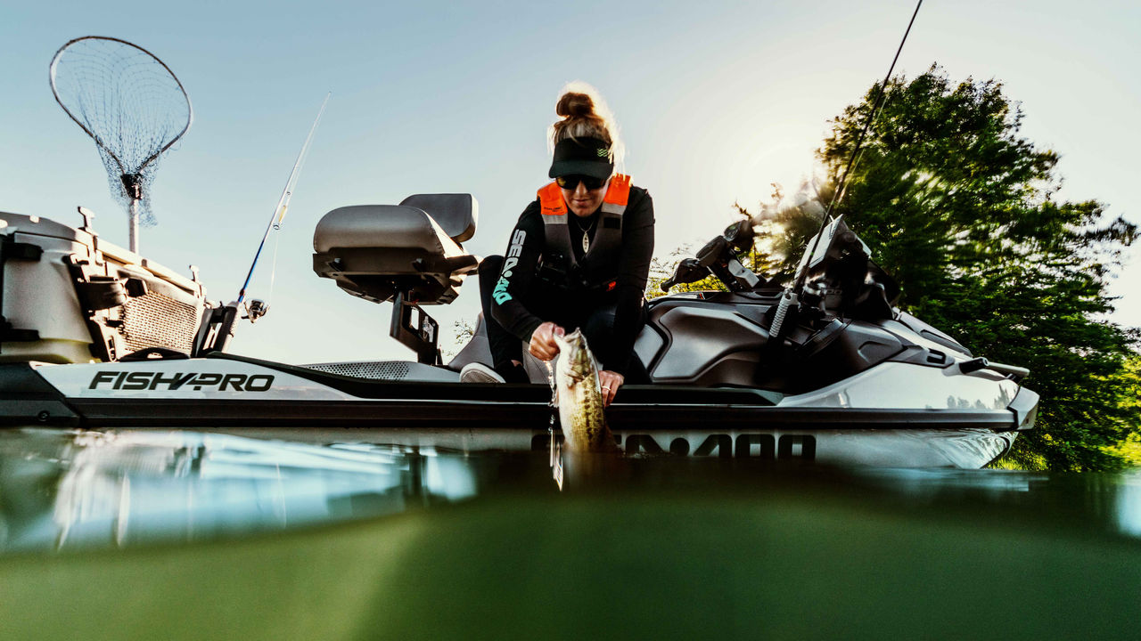 Woman fishing out a fish from her Sea-Doo Fish Pro personal watercraft