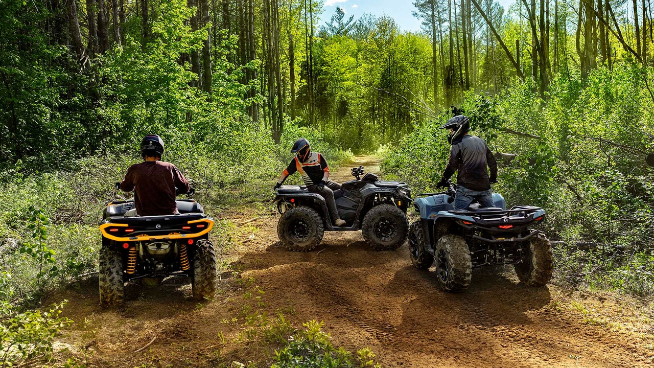 Mehrere Modelle des Can-Am Outlander ATV 2026 auf einem Waldweg