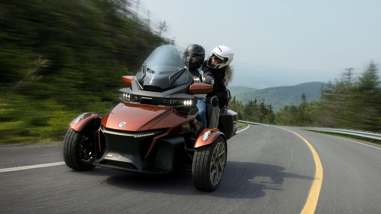 Ein Paar, das mit hoher Geschwindigkeit auf einem Can-Am Spyder RT Trike fährt.