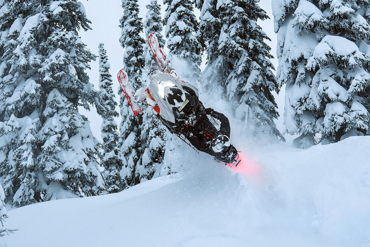 Rider doing a stunt in the snow on his 2027 Lynx Shredder RE
