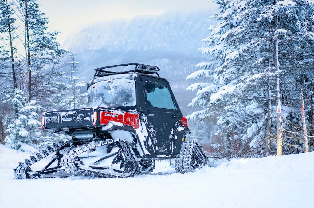 Mann fährt einen Can-Am Traxter im Schnee