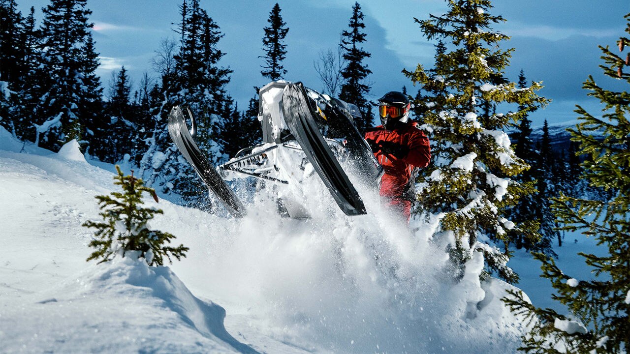 Lynx Brutal RE 2025 snowmobile ανηφορίζοντας στο σκοτεινό δάσος