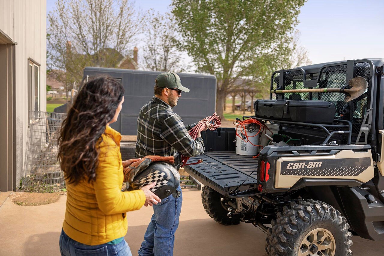Man and woman load cargo on their Can-Am traxter