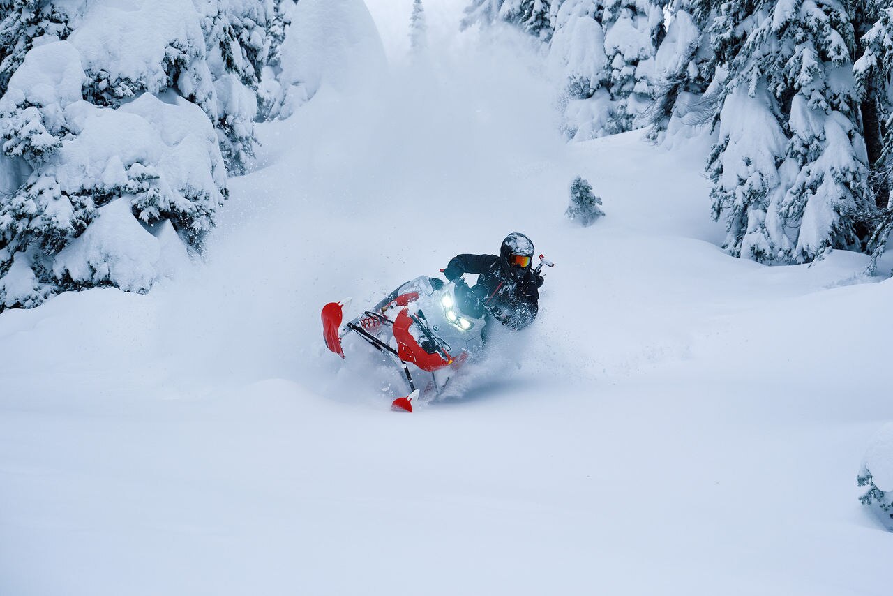 2027 Lynx Shredder snowmobile riding down a snowy forest