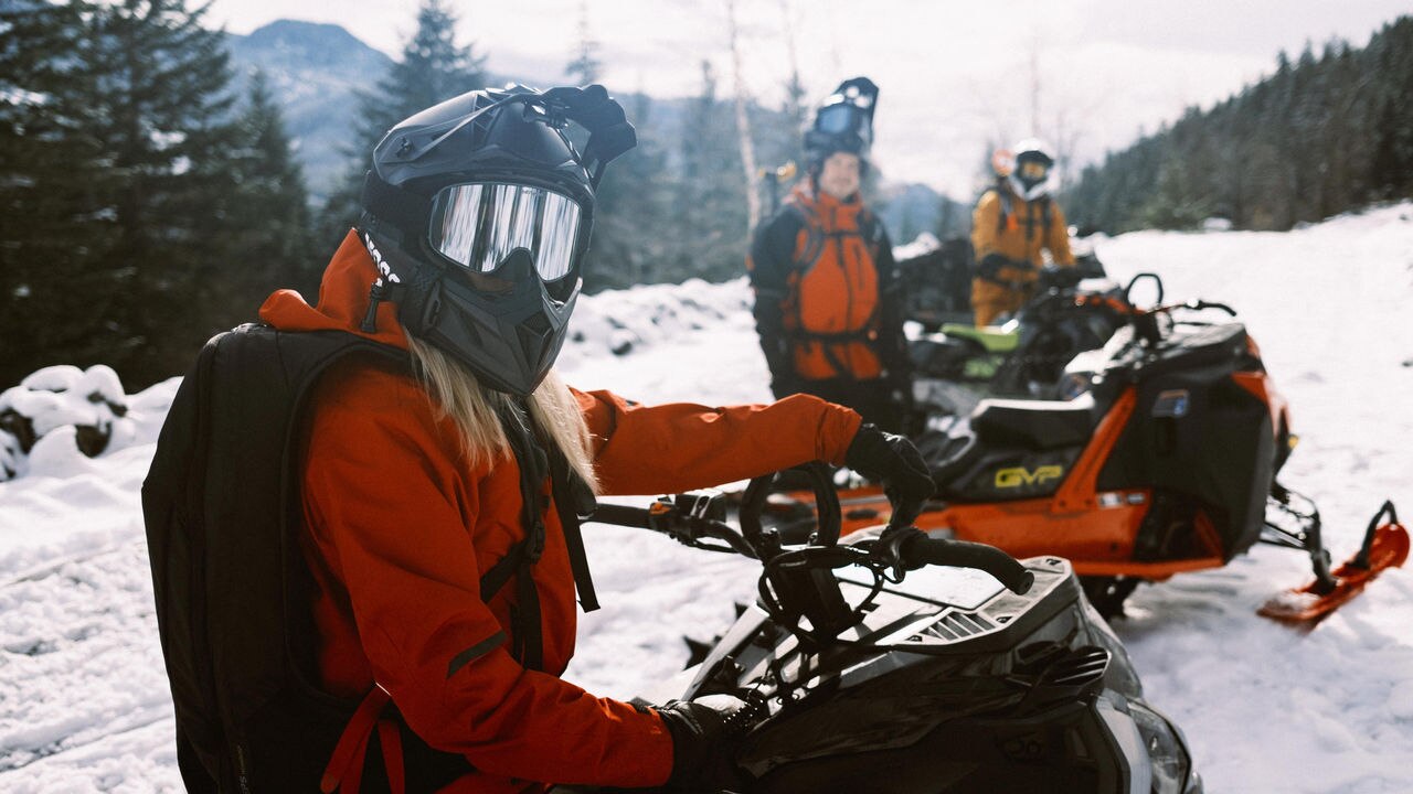 Ella Snäll on her sled with friends in the background
