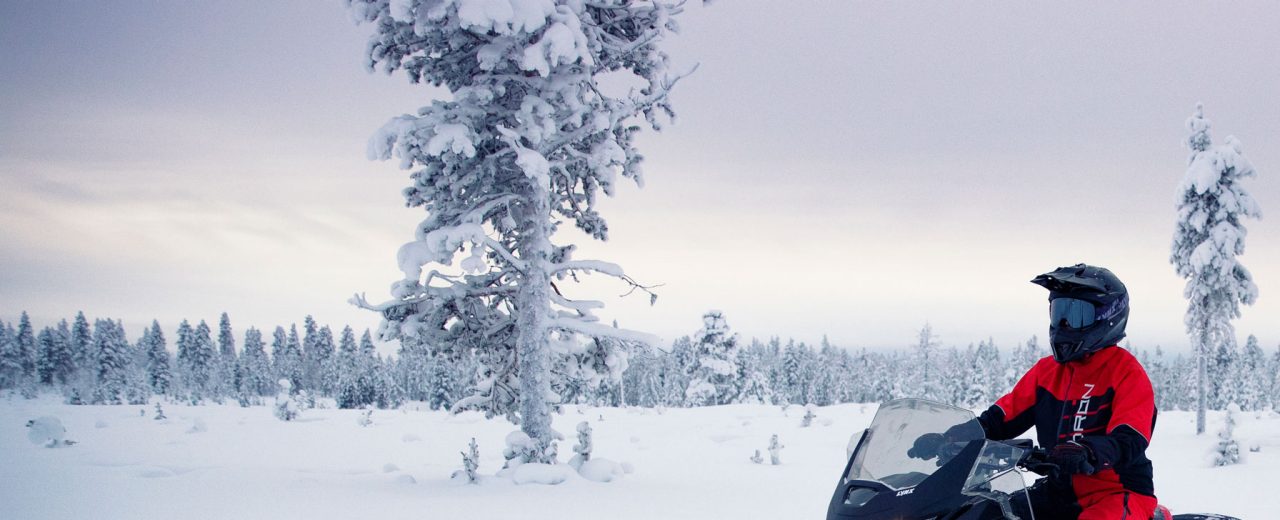 A man is driving his 2021 Lynx Xtrim Model on a snowy road