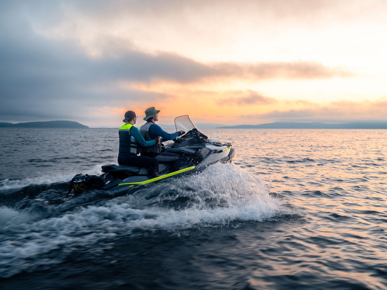 Two persons each riding a 2025 Sea-Doo Spark Trixx personal watercraft
