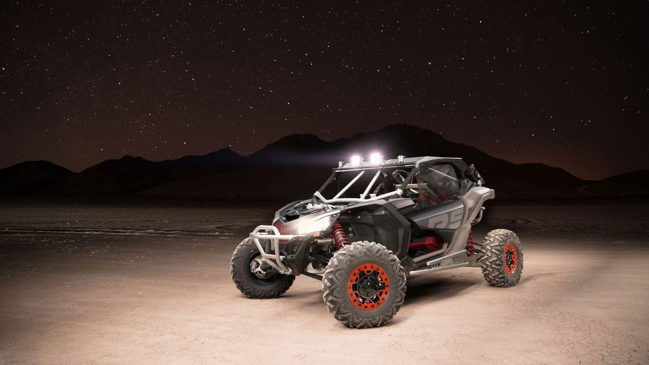 Man driving a Can-Am Maverick R in the sand
