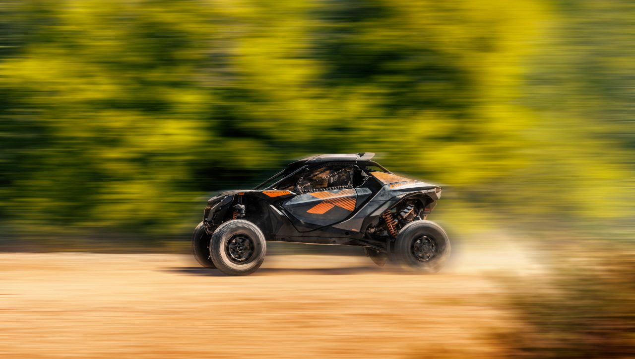 Man driving a Can-Am Maverick R in the sand