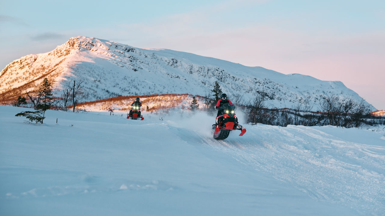 Two 2027 Lynx Rave RE snowmobile racing at high speed