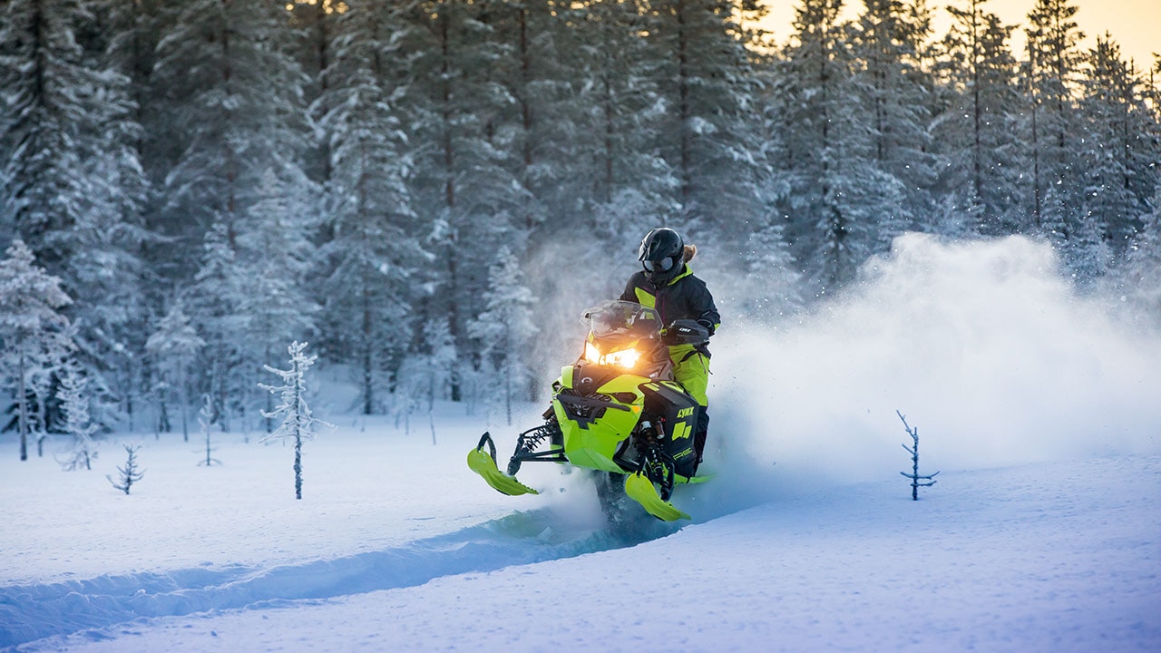 Naine hüppab läbi lume Lynx mootorkelguga