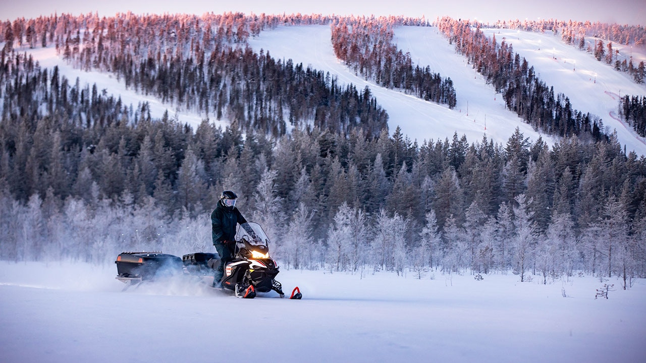 A man is driving his 2021 Lynx Xtrim Model on a snowy road