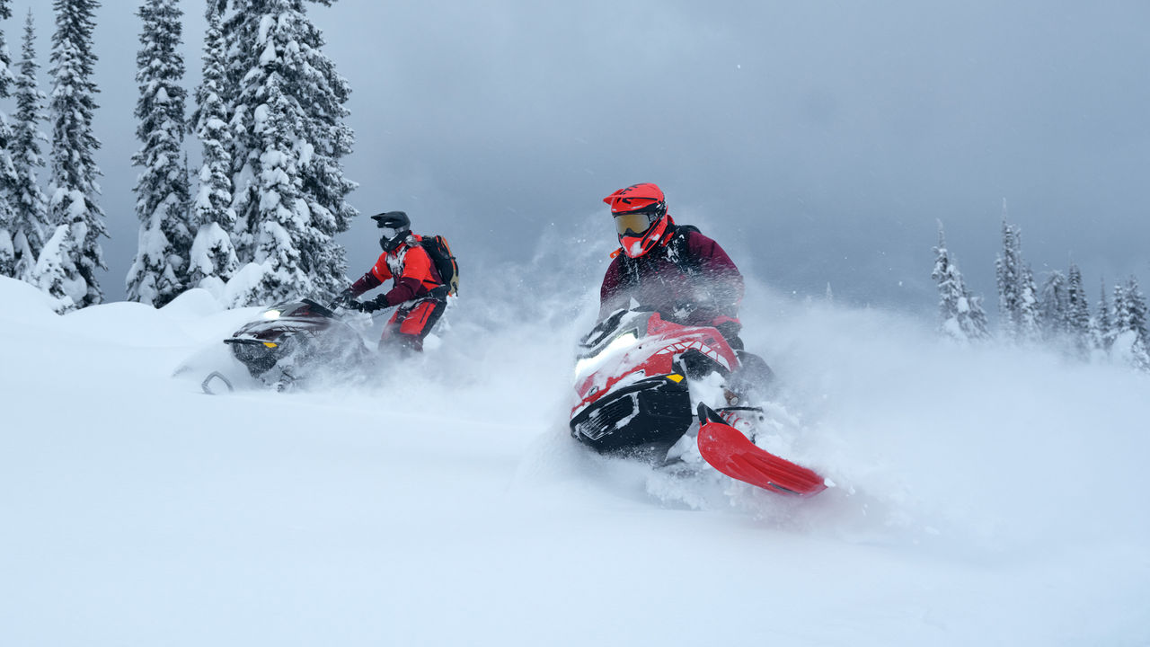 Lynx Shredder RE snowmobile making a turn in top of the mountain