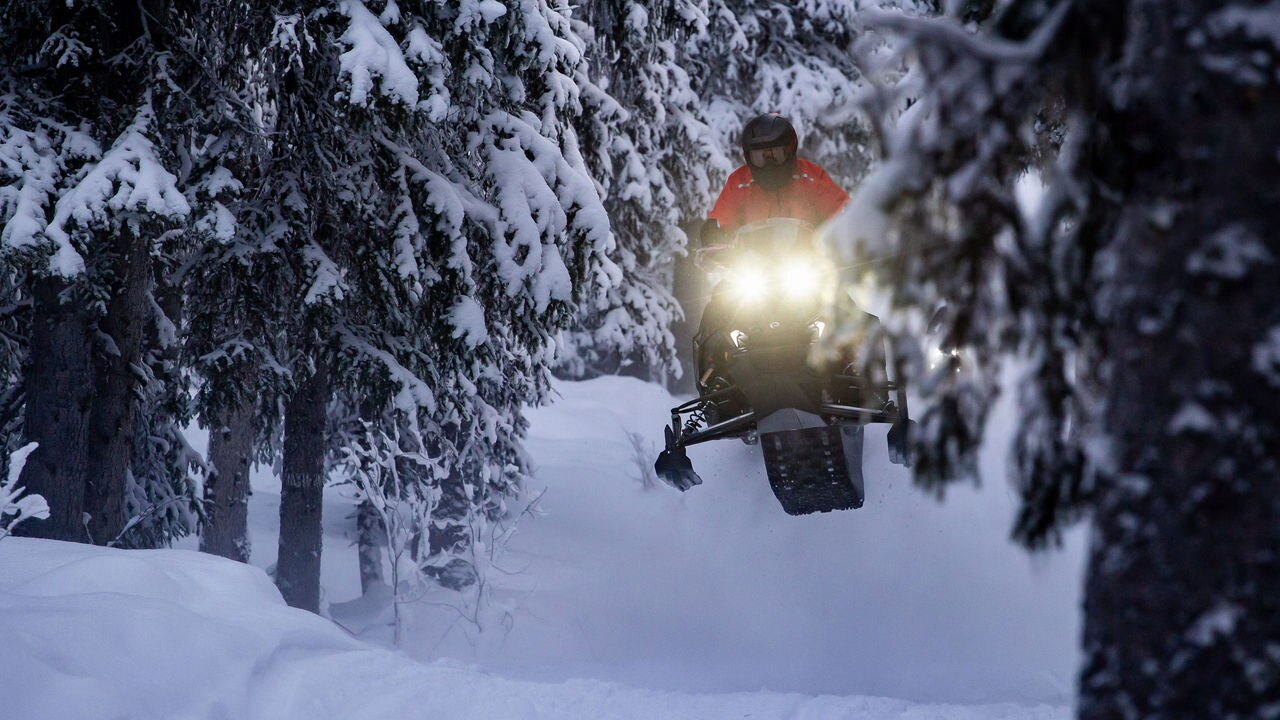 Lynx Rave RE 2025 snowmobile cornering on bumpy trail