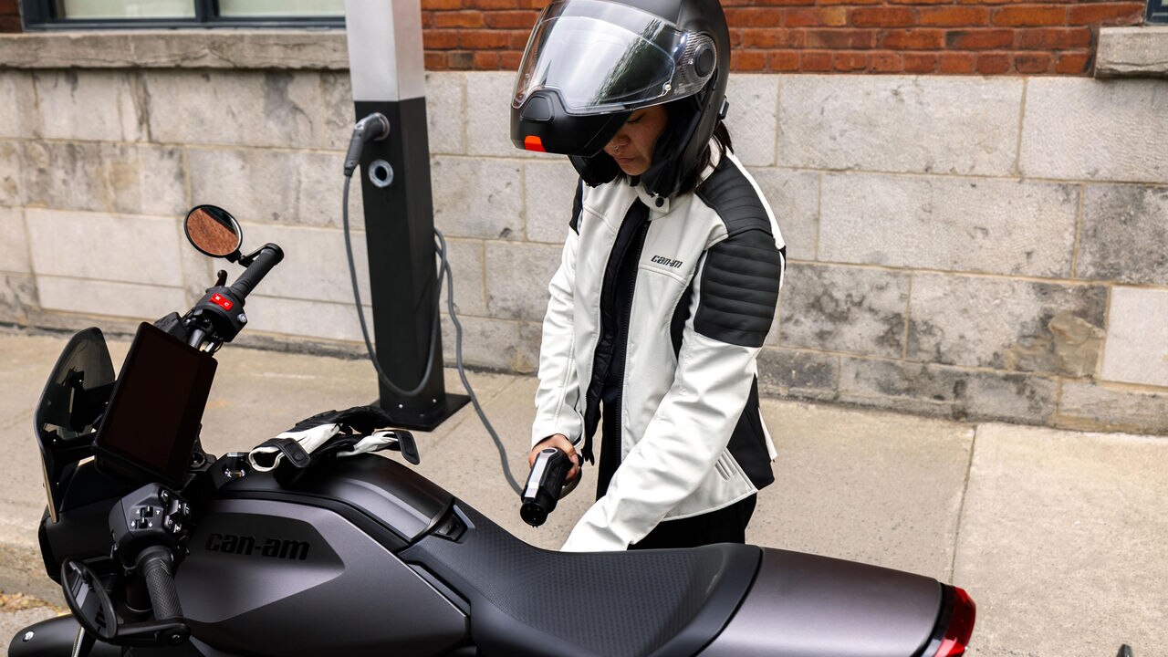 Une motarde prête à recharger sa moto électrique Can-Am