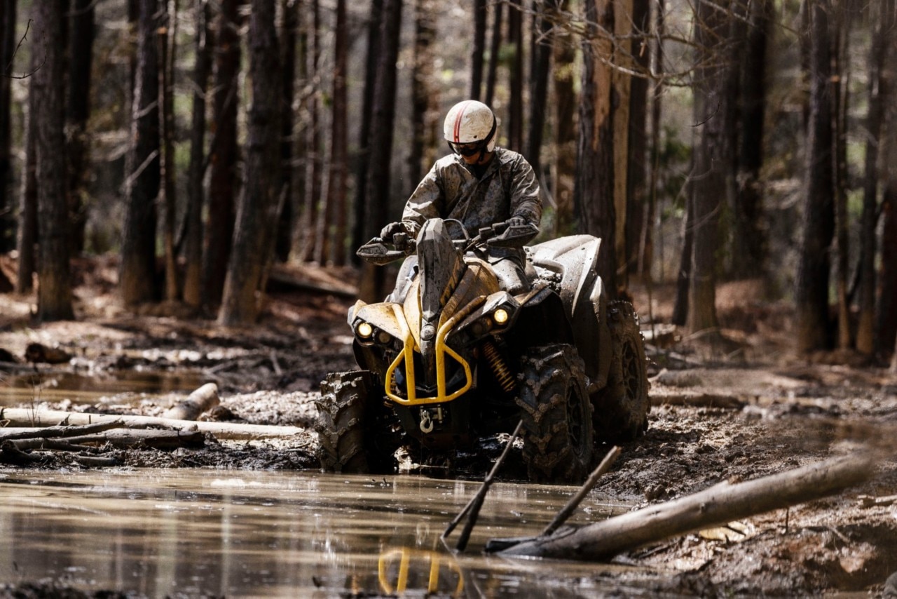 A man driving a Can-Am Renegade X mr 1000 in the mud