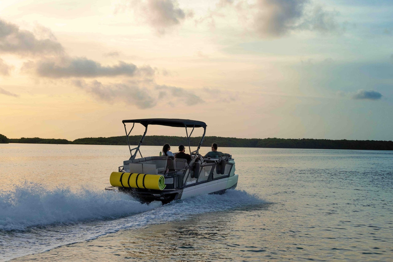 2026 Sea-Doo Switch Cruise pontoon boat on the water with a sunset