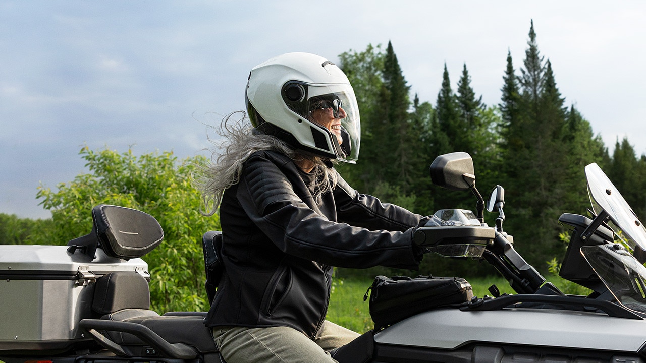 Une motarde au guidon d’un Can-Am 3-roues sur la route ouverte