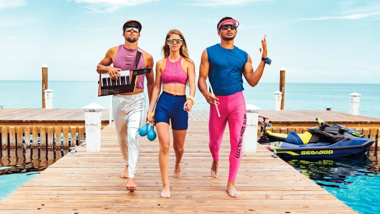 Groupe de trois personnes passant devant un Sea-Doo Wake Pro amarré