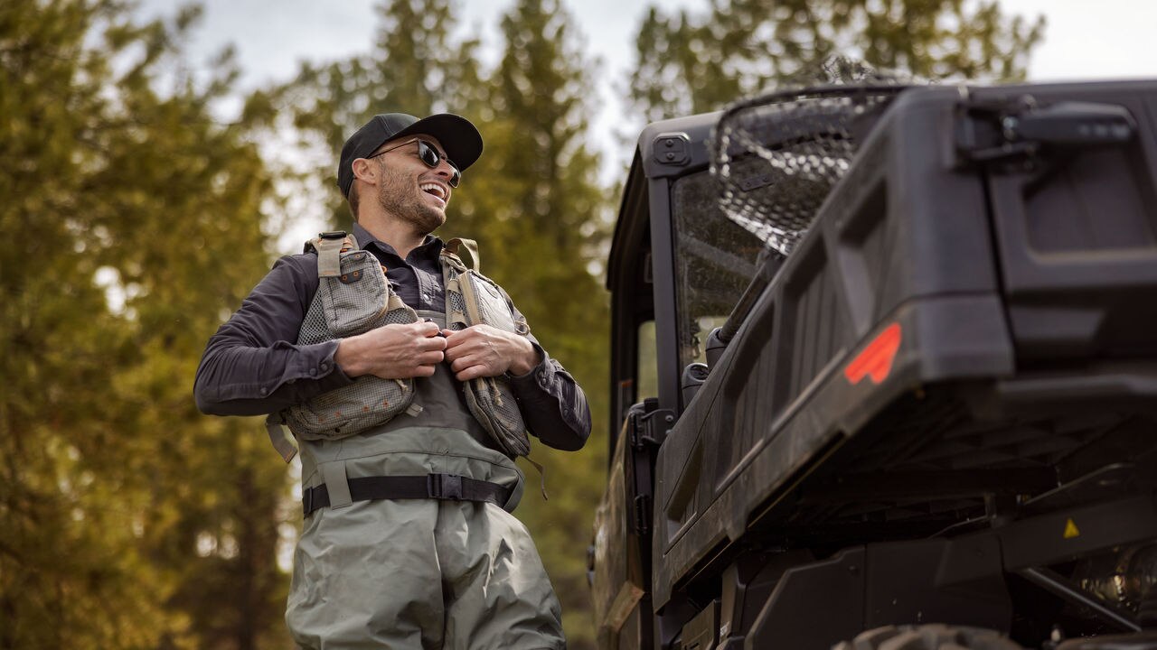 Man standing next to a Can-Am Traxter Pro vehicle 