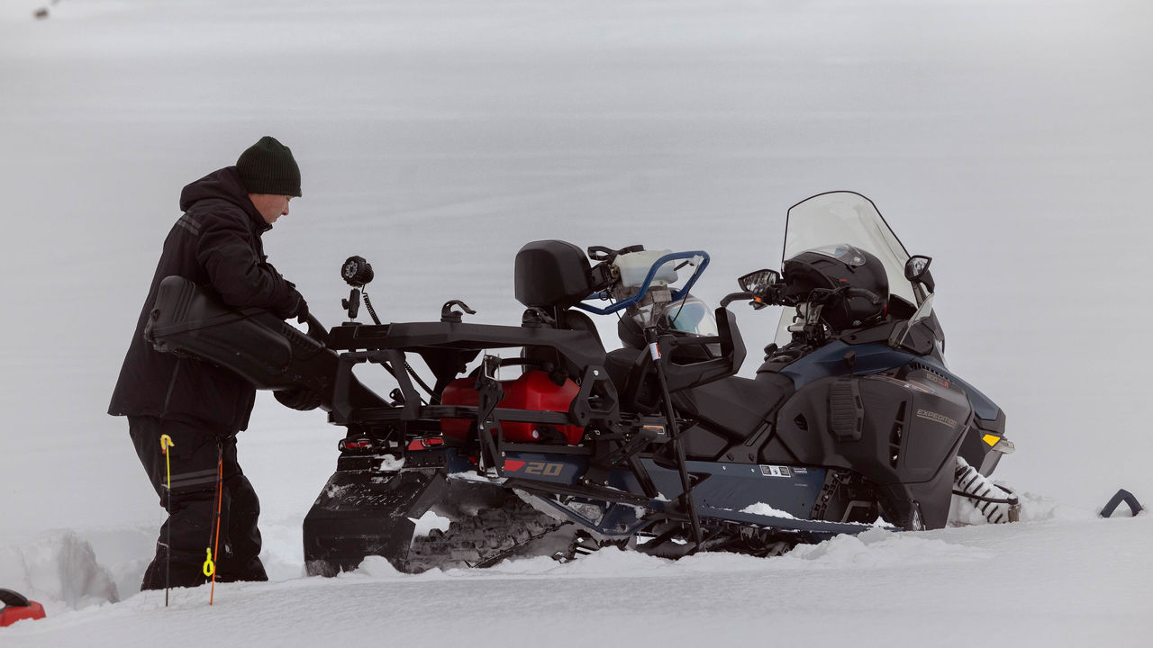 Vozač sprema predmete na svoje motorne sanjke Ski-Doo Expedition 2025