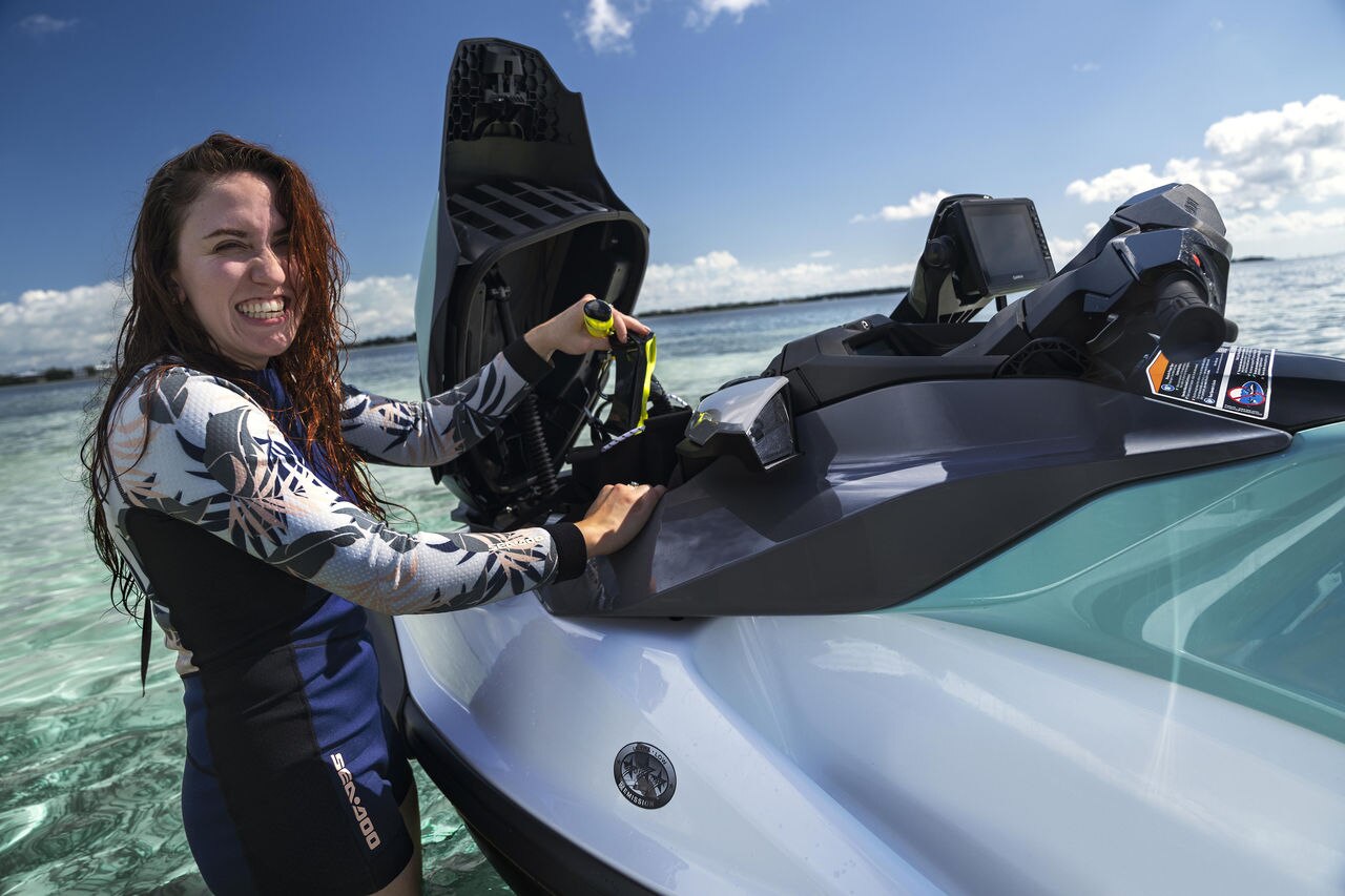 Žena stavlja ronilačko odjelo u prednje skladište GTI plovila