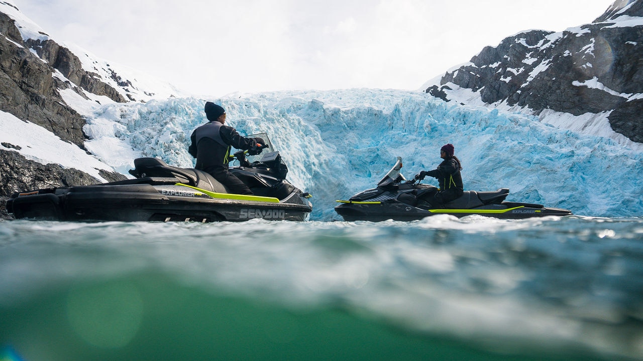Two Sea-Doo personal watercrafts idle on the water