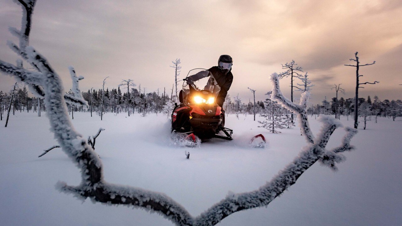 Riding the Lynx 59 Ranger snowmobile on powder snow