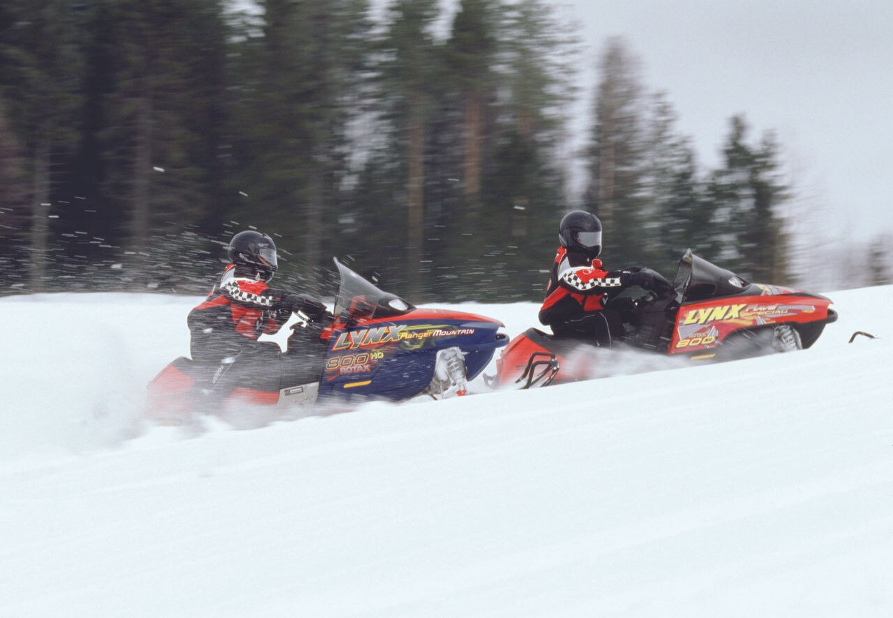 Lynx Rave and Ranger Mountain snowmobiles accelerating uphill