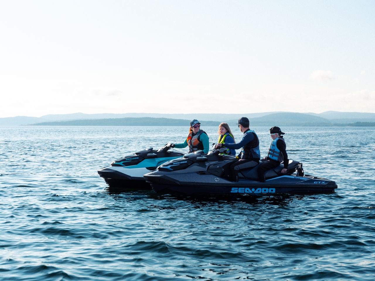 Family sitting on idle Sea-Doo personal watercrafts