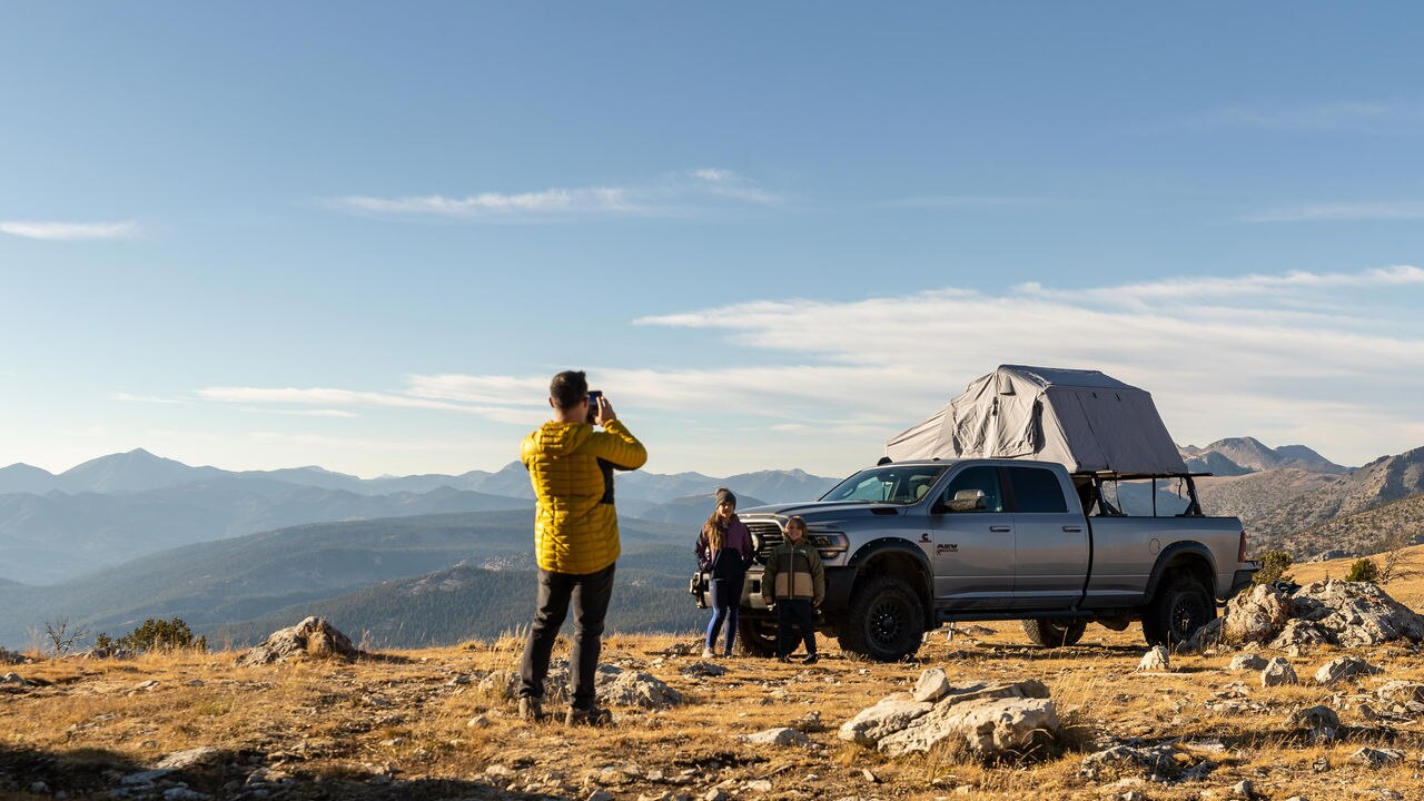 Tony Jenkins taking his two kids in photo at the top of a mountain