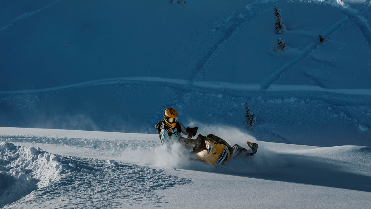 Возач изведува трик на Ski-Doo MXZ NEO од 2025 година на врвот на снежна планина