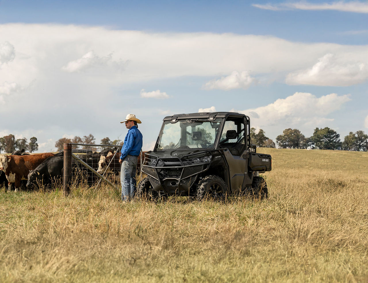Farmer odpoczywający przy swoim pojeździe Can-Am Traxter wśród krów