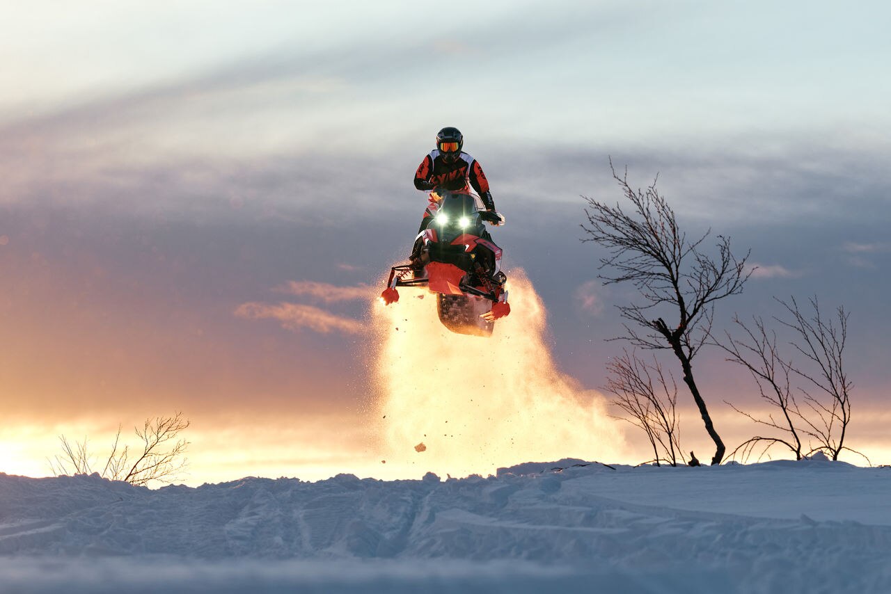 Rider performing a jump on a 2027 Lynx Rave RE snowmobile 