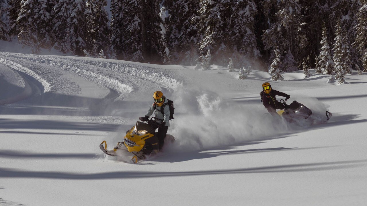 Dwa skutery Ski-Doo 2025 jadące w głębokim śniegu